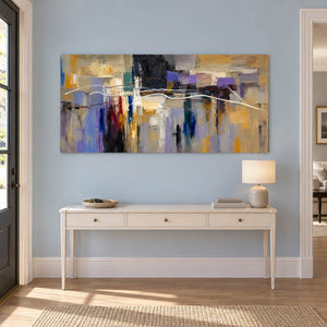 Hand-painted textured abstract wall art in golden ochre, smoky violet, slate blue, and charcoal, displayed in an entrance hall without an outer frame.