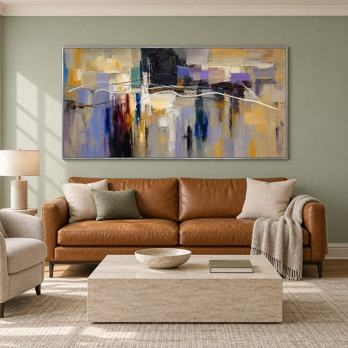 Hand-painted textured abstract wall art in golden ochre, smoky violet, slate blue, and charcoal, displayed in a living room in a silver frame.