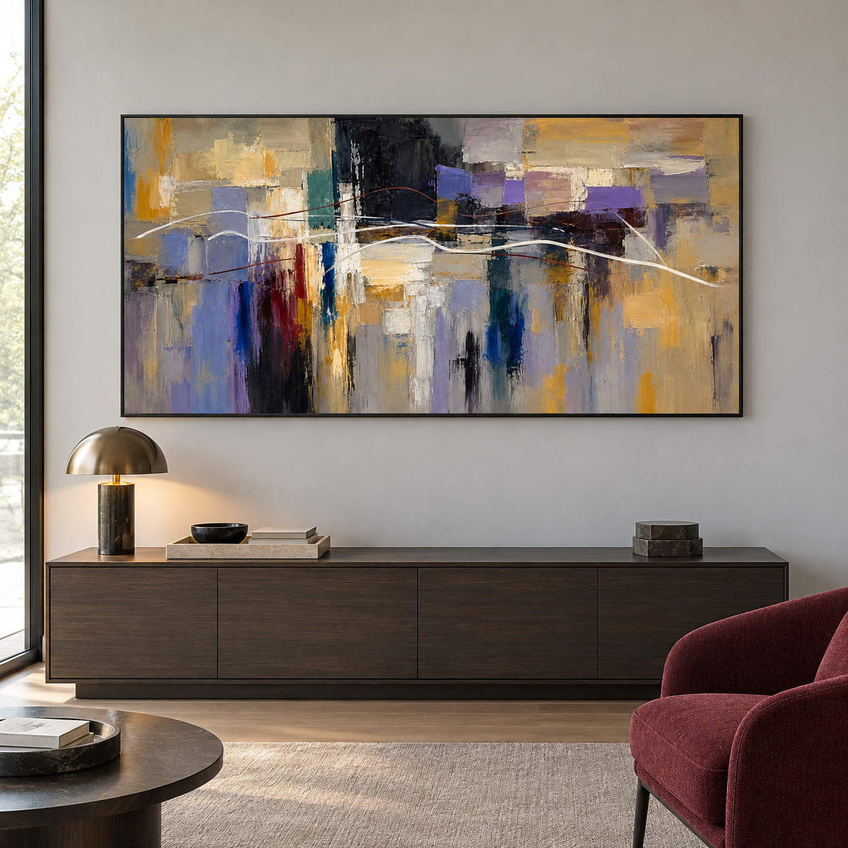 Hand-painted textured abstract wall art in golden ochre, smoky violet, slate blue, and charcoal, displayed in a lounge in a black frame.