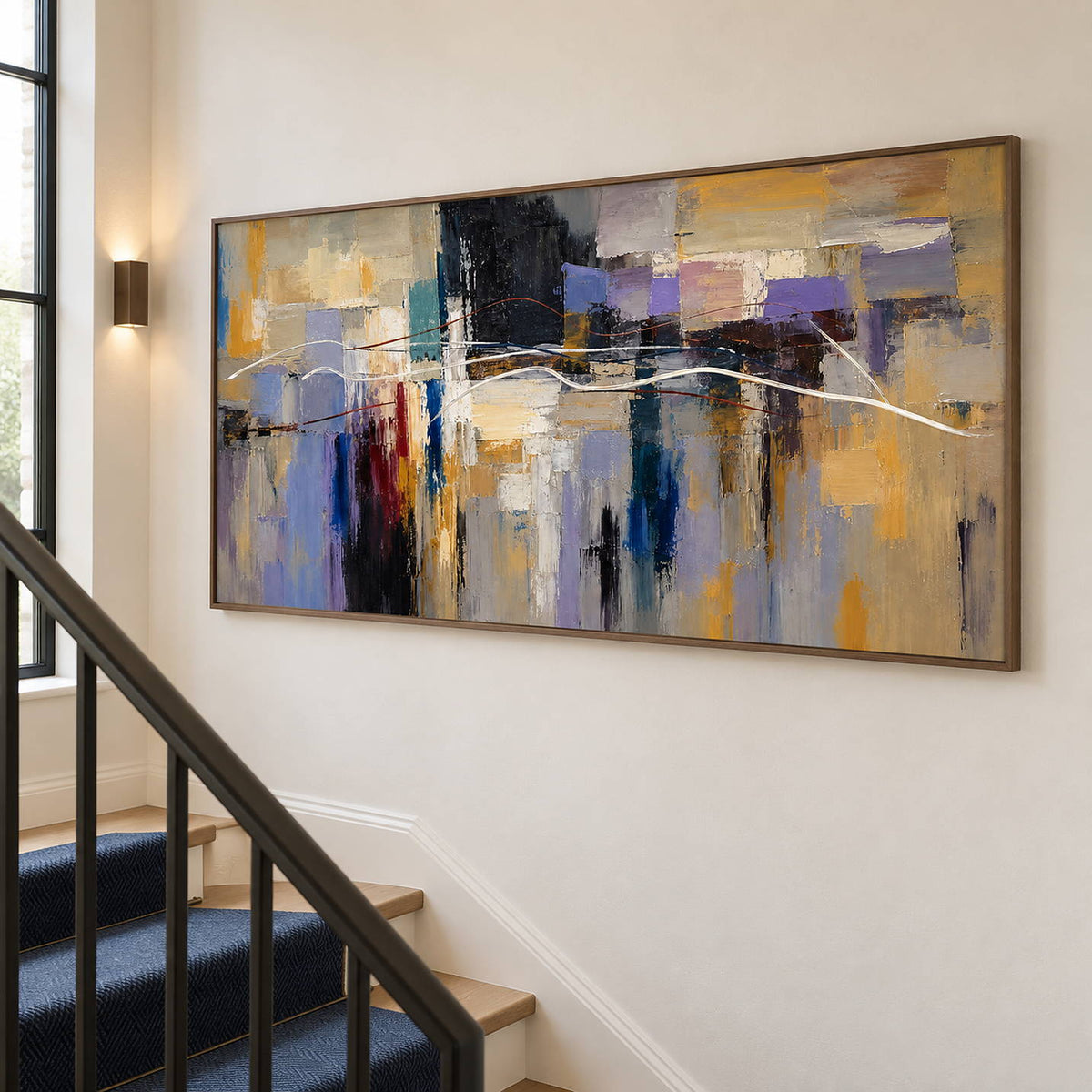 Hand-painted textured abstract wall art in golden ochre, smoky violet, slate blue, and charcoal, displayed beside a staircase in a brown wood frame.