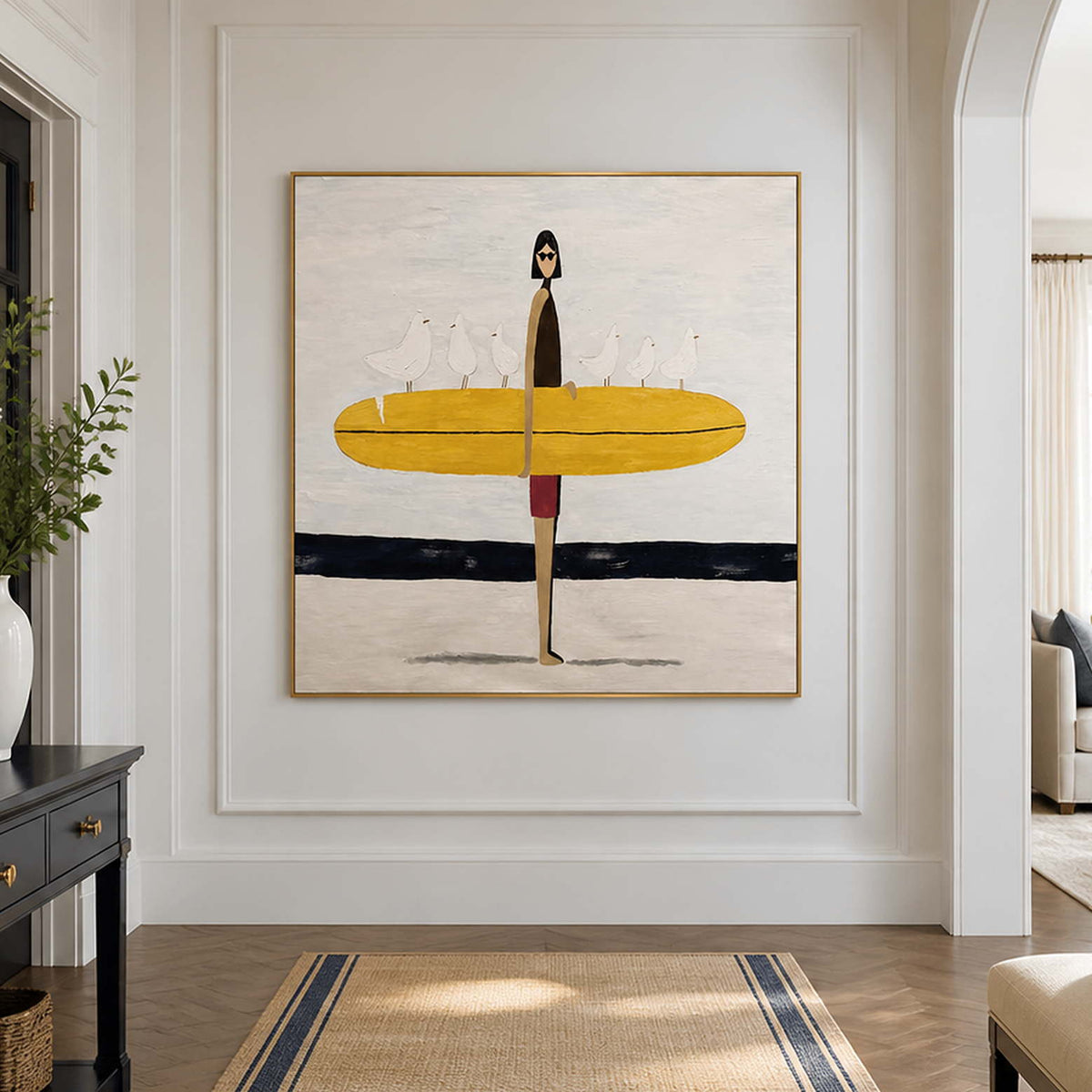 Gold framed surfer artwork on a bright hallway wall beside an open doorway.