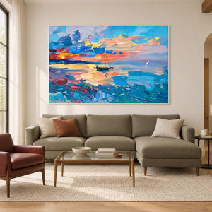 Colorful sunset sailboat painting above a green sectional sofa.