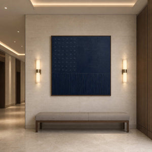 Navy relief artwork anchoring a softly lit boutique hotel corridor.