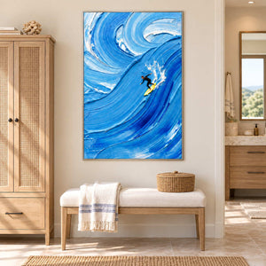Riding the Wave in a silver frame above a cushioned bench beside a rattan-front cabinet in a bathroom dry area.