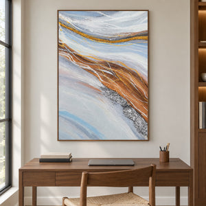 In a study with a desk, an artwork with a brown wood-look frame shows pale blue-gray bands curving around ochre areas with fine white lines.