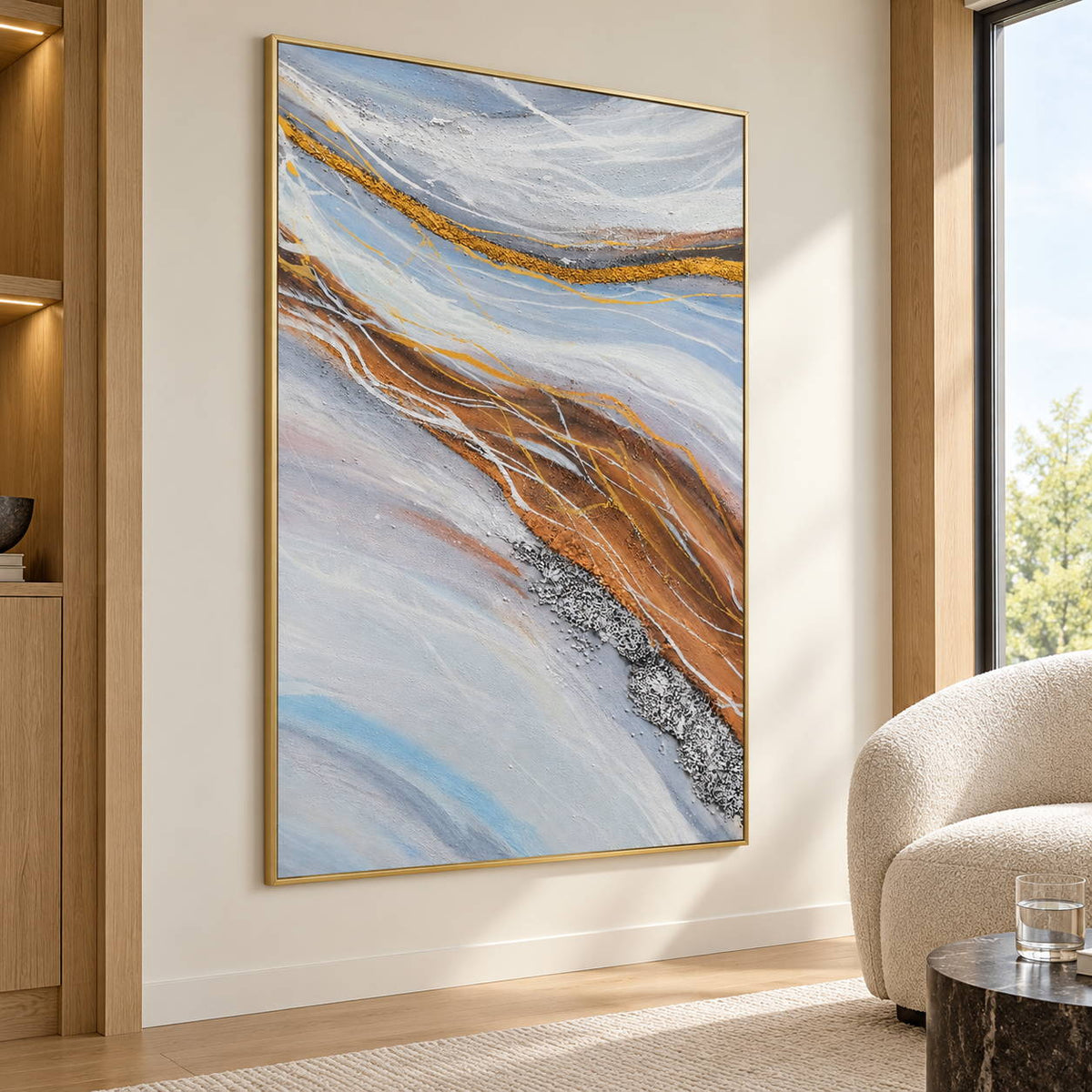In a seating area, an artwork with a gold-colored frame shows pale blue-gray bands curving around ochre areas with fine white lines.