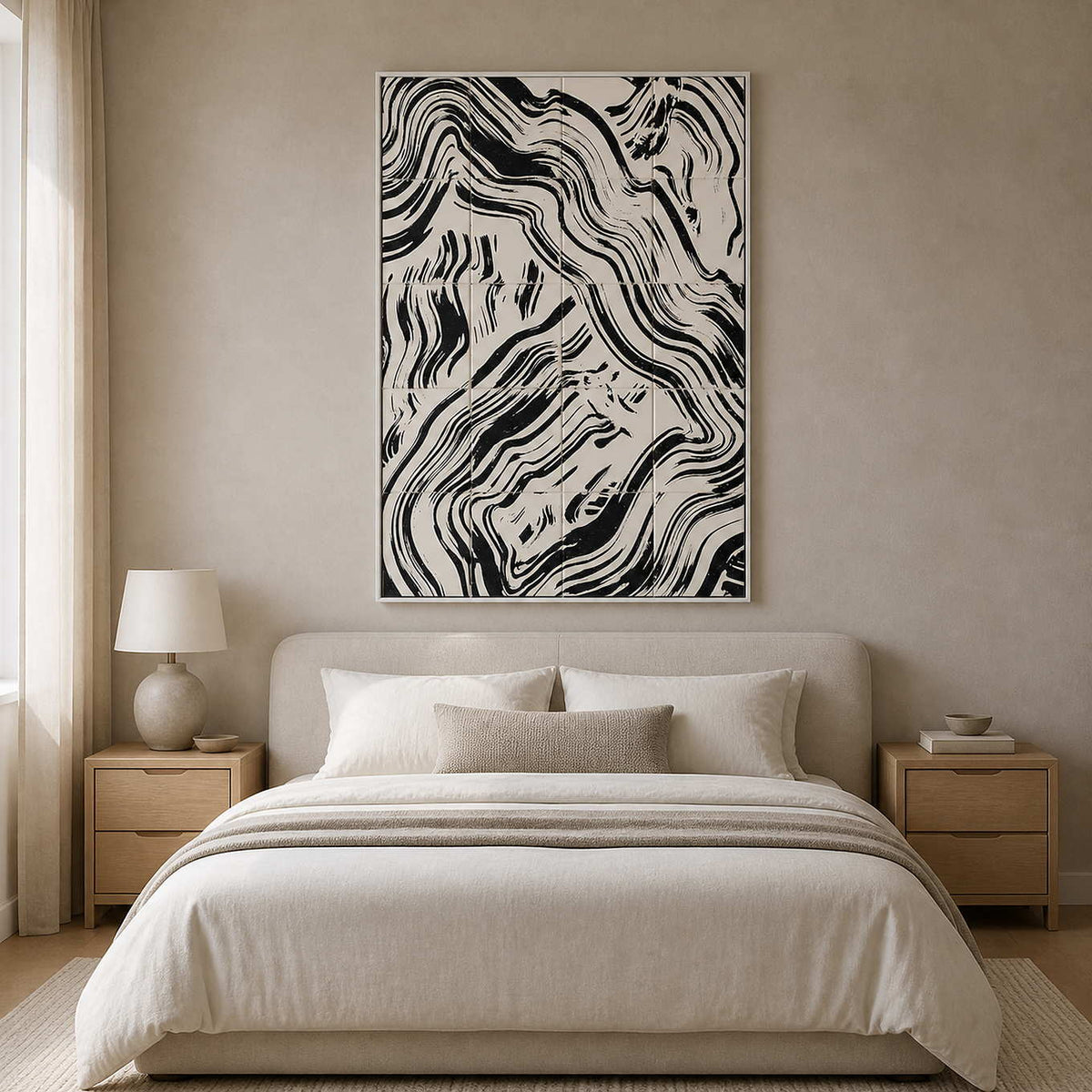White framed abstract painting with offset black currents above a pale upholstered bedroom headboard.