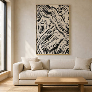 Gold framed abstract artwork with black flowing bands above a cream living room sofa.