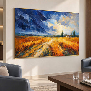 Golden field and winding path painting beneath a blue and cream sky in a gold frame in a reception lounge.