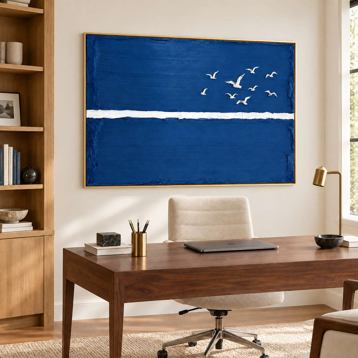 Room to Fly in a gold frame above a wood desk and cream office chair beside tall wood shelving.