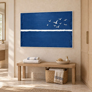 Room to Fly in a white frame above a wood bench with folded towels and a woven basket beside a bathroom vanity.