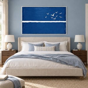 Room to Fly in a white frame above a cream bed with soft blue bedding against a blue-gray wall.