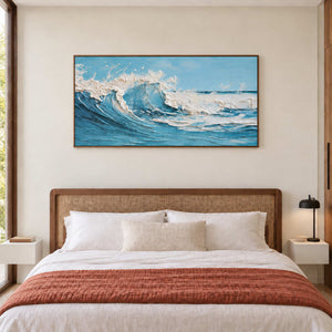 Wave seascape over a woven headboard and white bed with a rust throw.