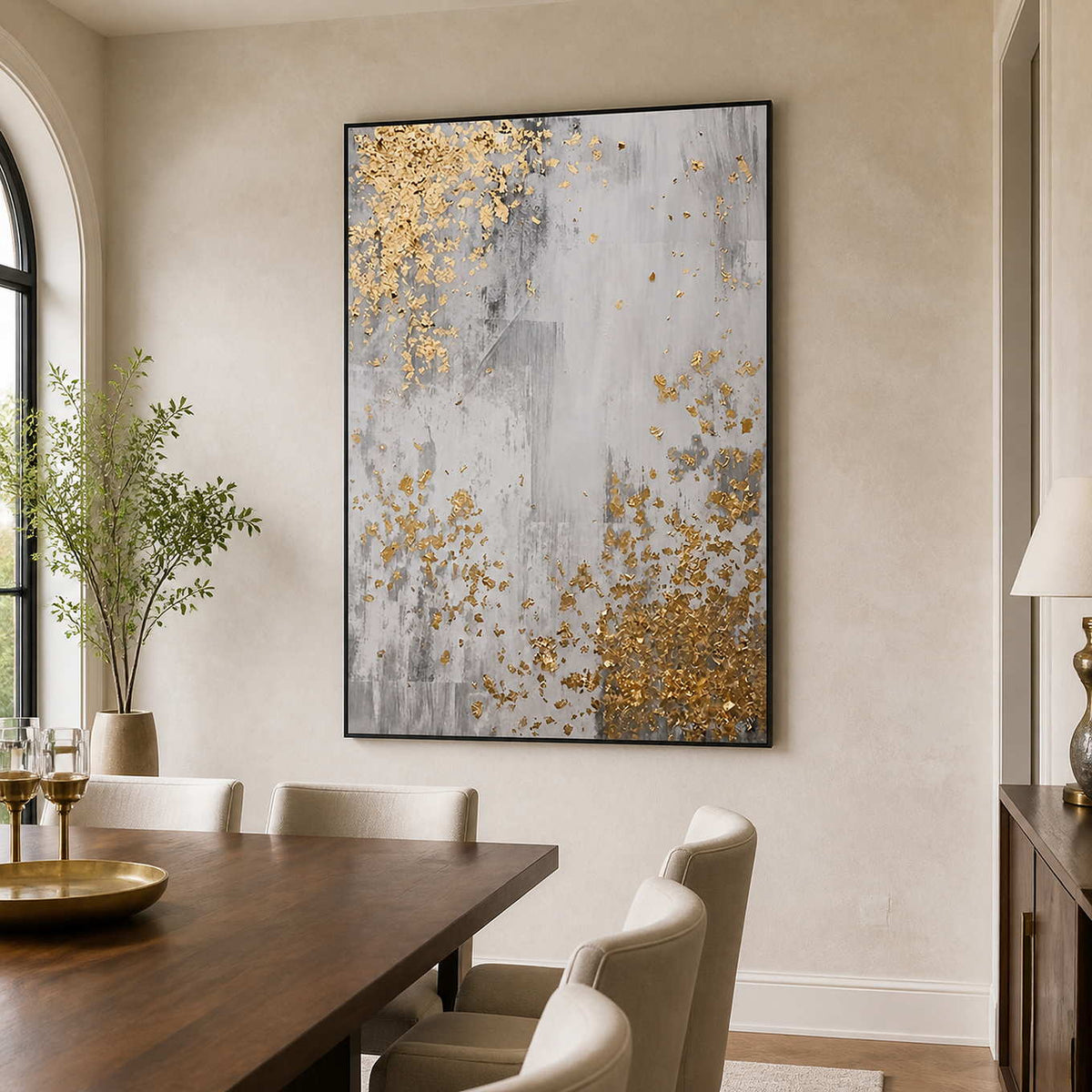 Black framed gray and gold abstract artwork beside a wooden dining table.