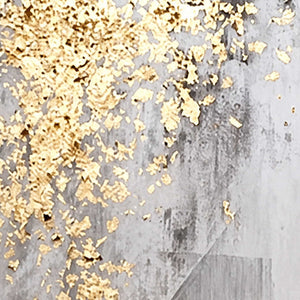 Close view of irregular gold flecks over layered gray brushwork and pale scraped marks.