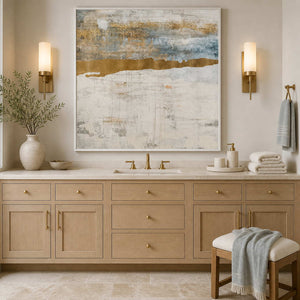 White framed cream and blue abstraction above a light wood bathroom vanity.