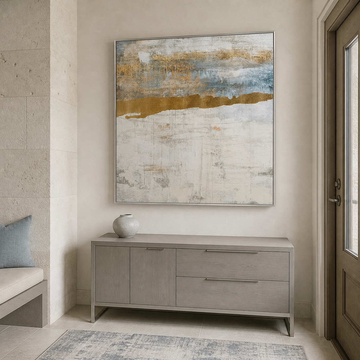 Silver framed pale horizon artwork above a gray cabinet beside the entry door.