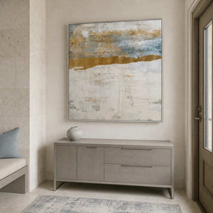 Silver framed pale horizon artwork above a gray cabinet beside the entry door.