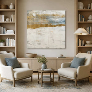 Frameless square horizon painting between bookshelves above two cream reading room armchairs.