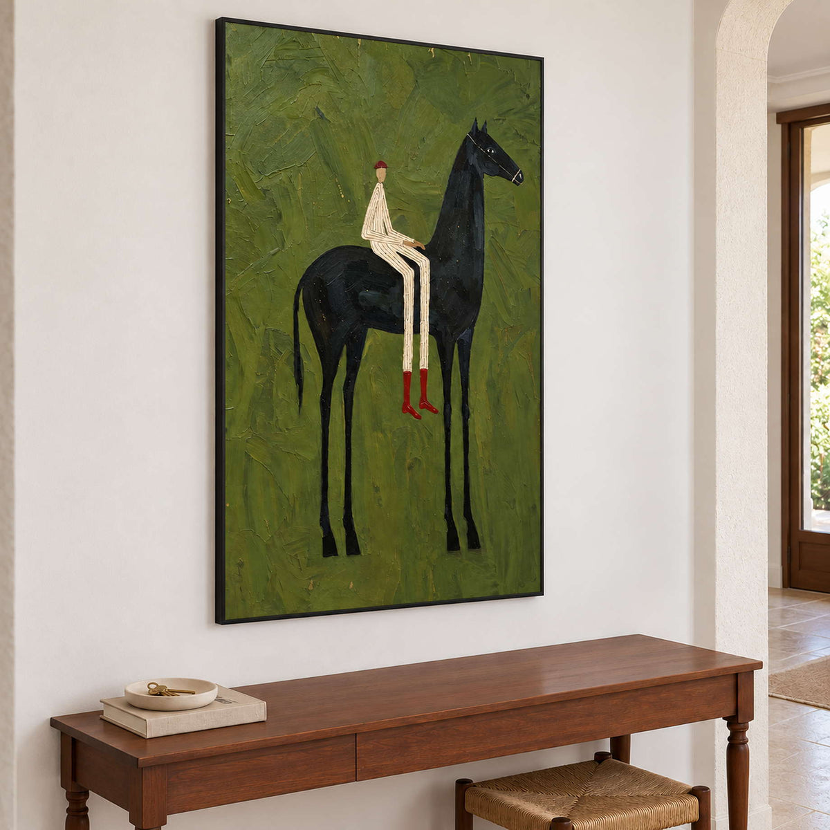 Angled view of green equestrian artwork over a long wooden console.