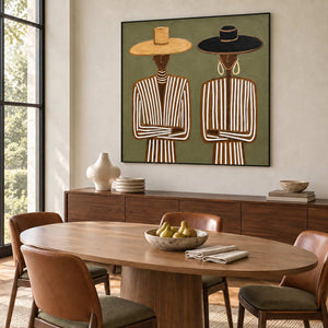 Shared Understanding in a black frame above a dark sideboard beside an oval wood dining table and tan leather chairs.