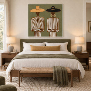 Shared Understanding in a white frame above an olive upholstered bed with white linen and a mustard cushion.