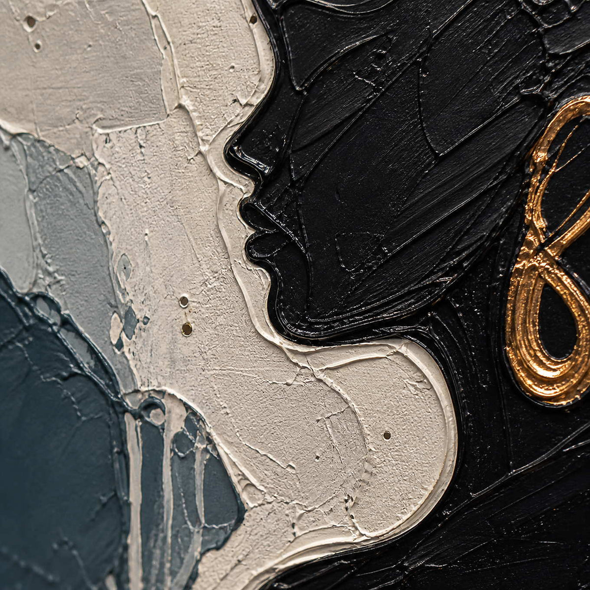 Close-up of black profile relief and a gold-copper painted earring.