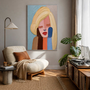 Textured portrait artwork displayed beside a relaxed reading corner.