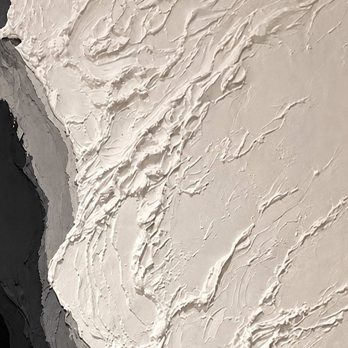 Close view of raised ivory paint ridges meeting curved gray and black layers.