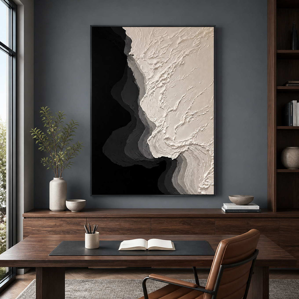 Black framed ivory relief artwork displayed above a desk in a home study.