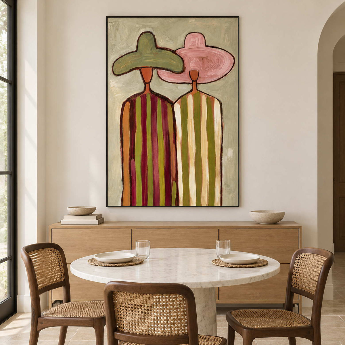 Tall hat portrait behind a round dining table with woven chairs.