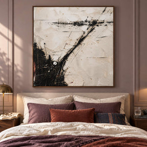 Ivory abstract painting with sweeping black marks and fine crossing lines in a brown wood frame in a bedroom.