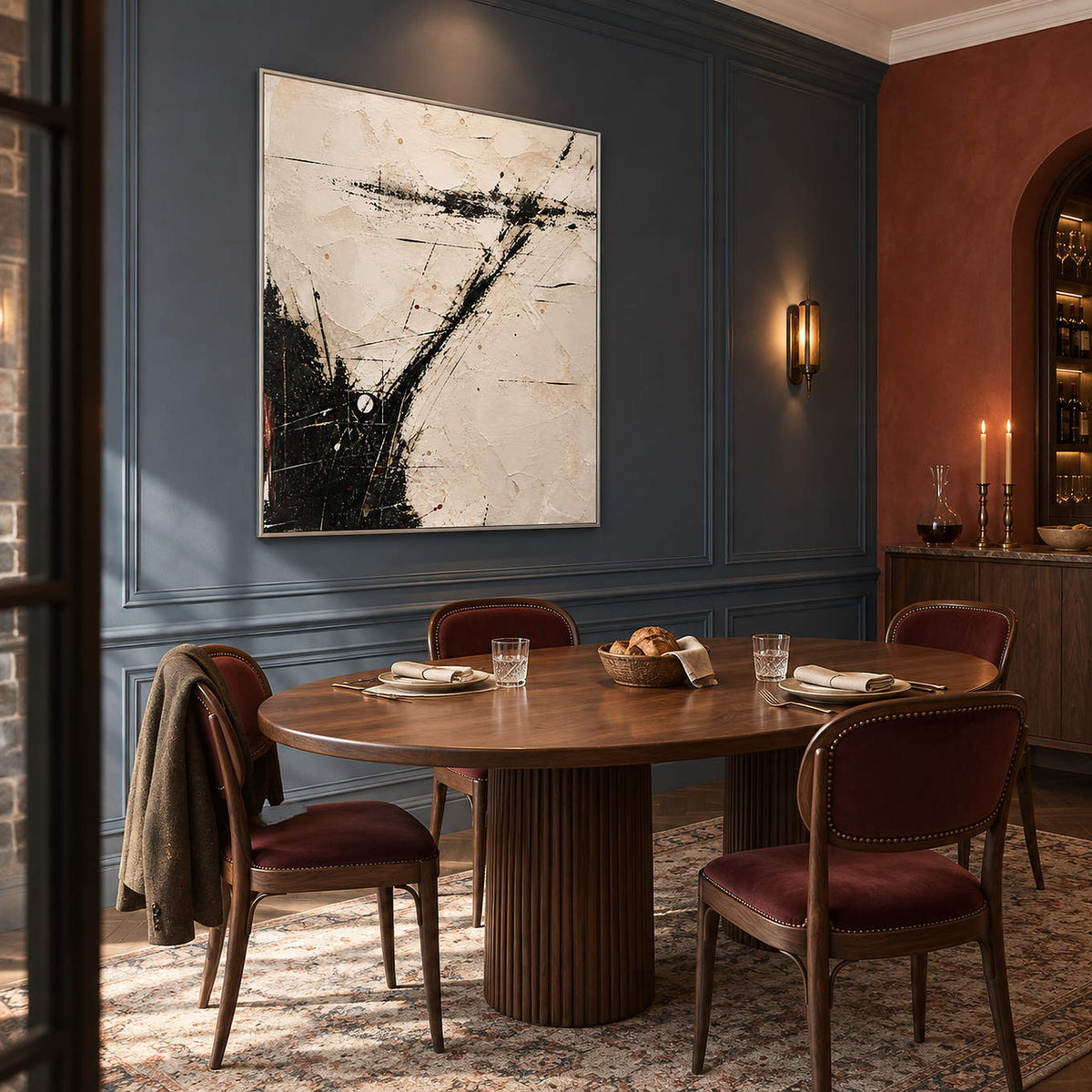 Ivory abstract painting with sweeping black marks and fine crossing lines in a silver frame in a dining room.