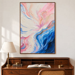 Cream and pink folds flowing into deep blue curves at the lower right in an artwork with a brown wood-look frame, displayed in a study with a desk.