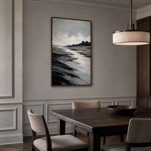Monochrome coastal landscape wall art in a dining room with a wood frame.