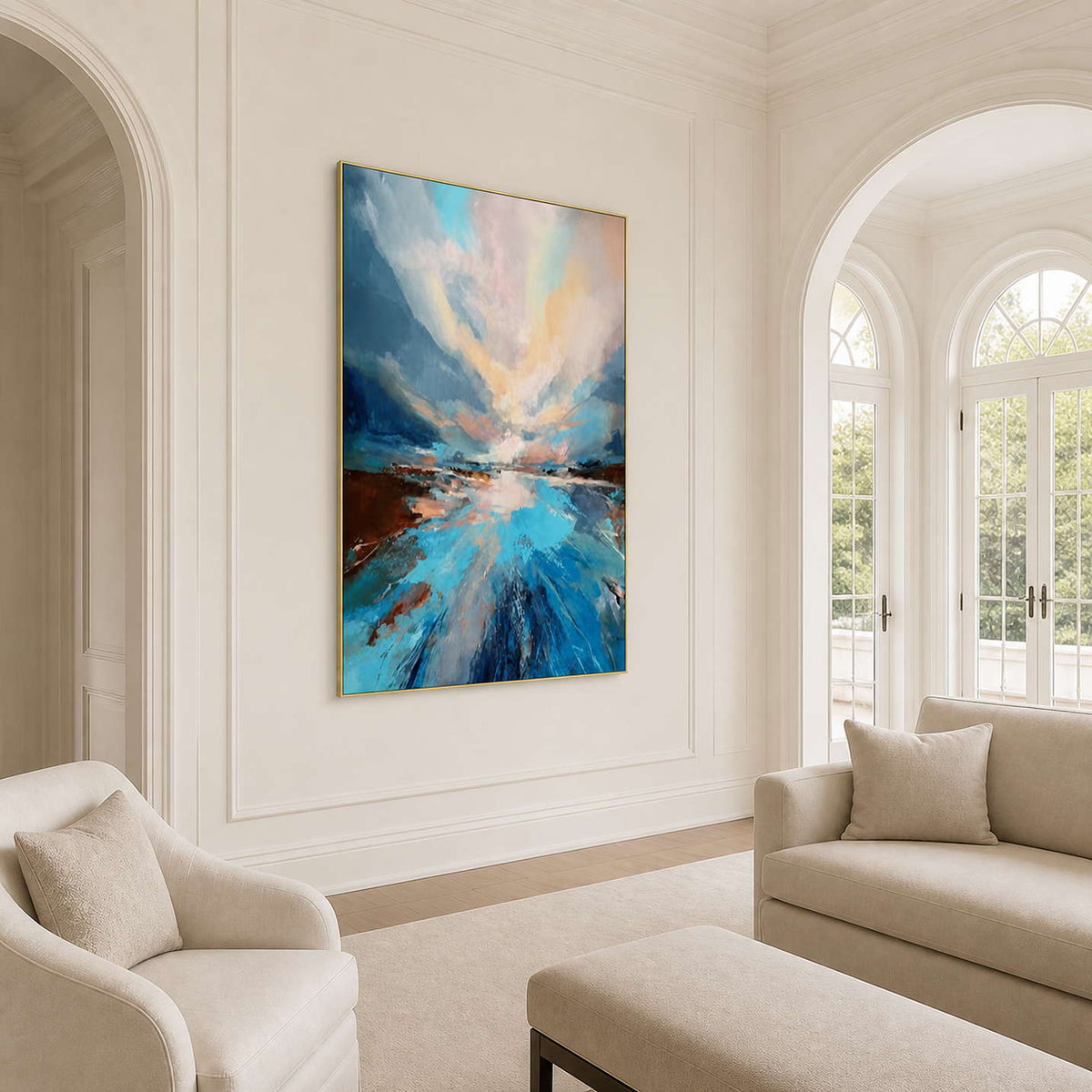 Gold framed blue landscape beside cream seating and tall arched living room windows.