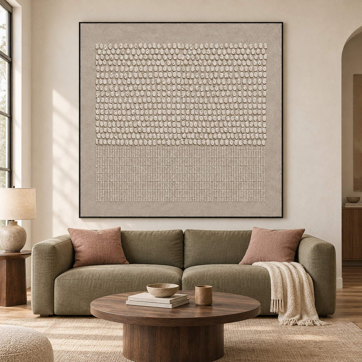 Taupe painting with orderly ivory relief ovals and fine linear texture in a black frame in a living room.