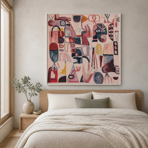 White framed pink symbol artwork above a wood headboard in a neutral bedroom.