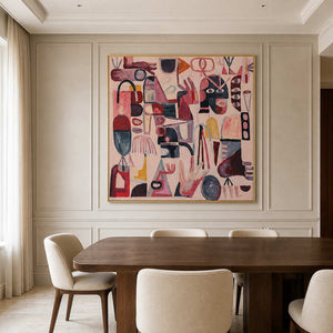 Gold framed playful pink artwork above a dining table against pale paneled walls.