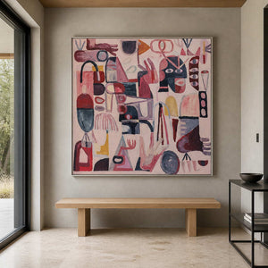 Silver framed abstract symbol painting above a wood bench in a stone entryway.