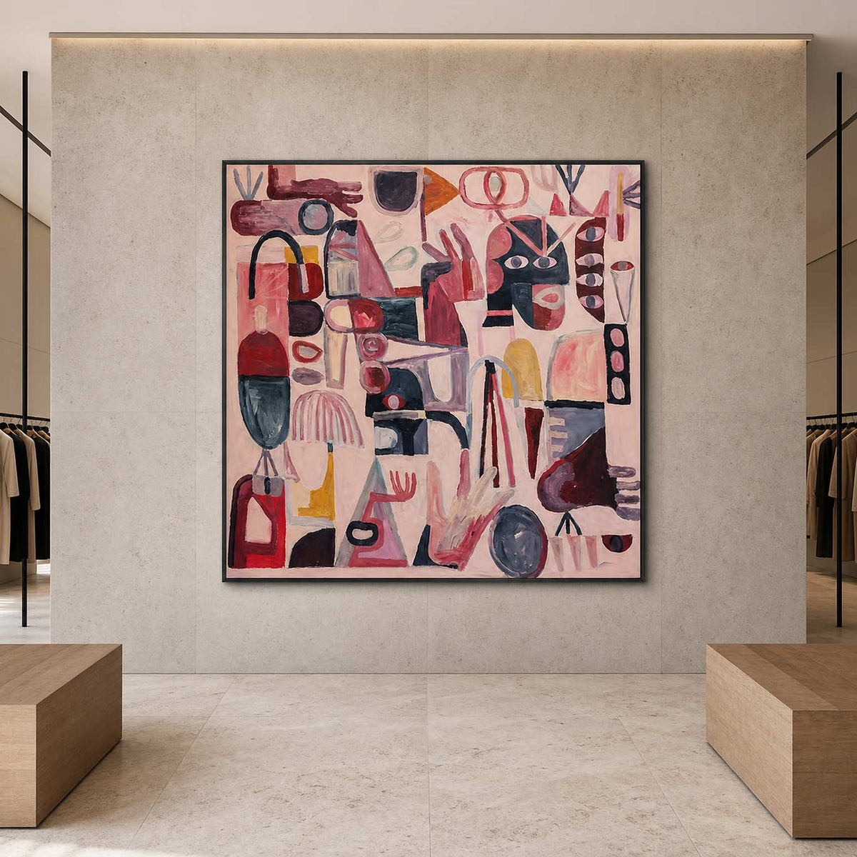 Front view of black framed pink symbol artwork between clothing displays in a showroom.