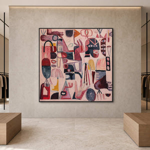Front view of black framed pink symbol artwork between clothing displays in a showroom.
