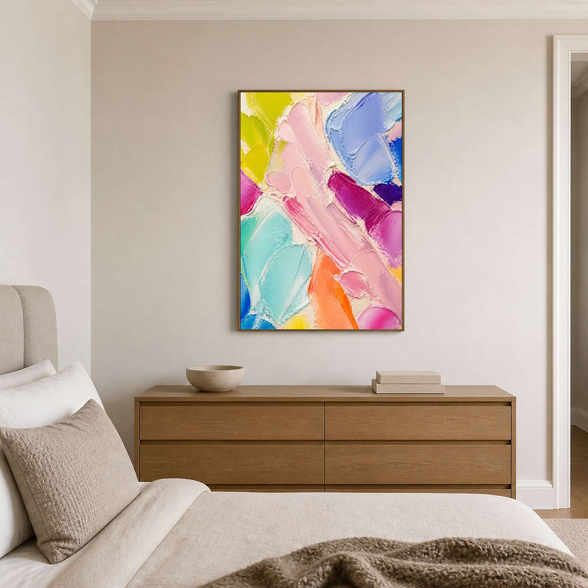 Soft colorful abstract wall art displayed above a warm neutral bedroom dresser.
