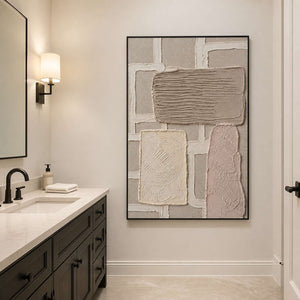 Neutral abstract wall art in a black frame beside a bathroom vanity.