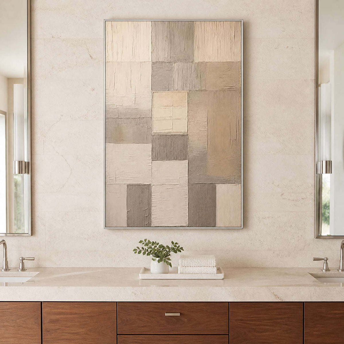 Silver framed cream and taupe artwork above a pale bathroom vanity counter.