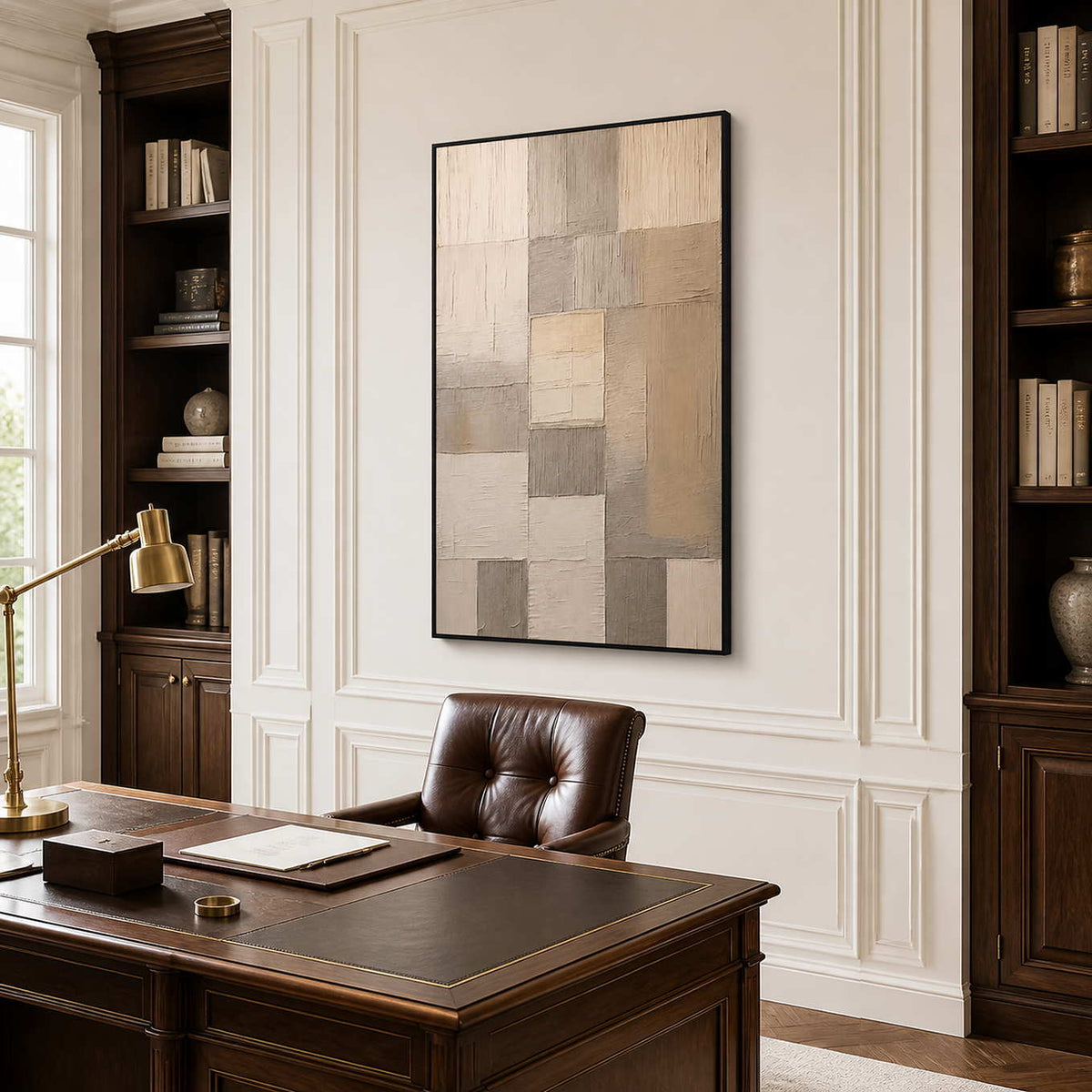 Black framed geometric artwork behind a leather desk chair in a study.