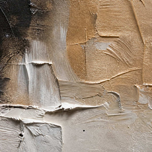 Close view of raised beige paint strokes layered over cream and black.