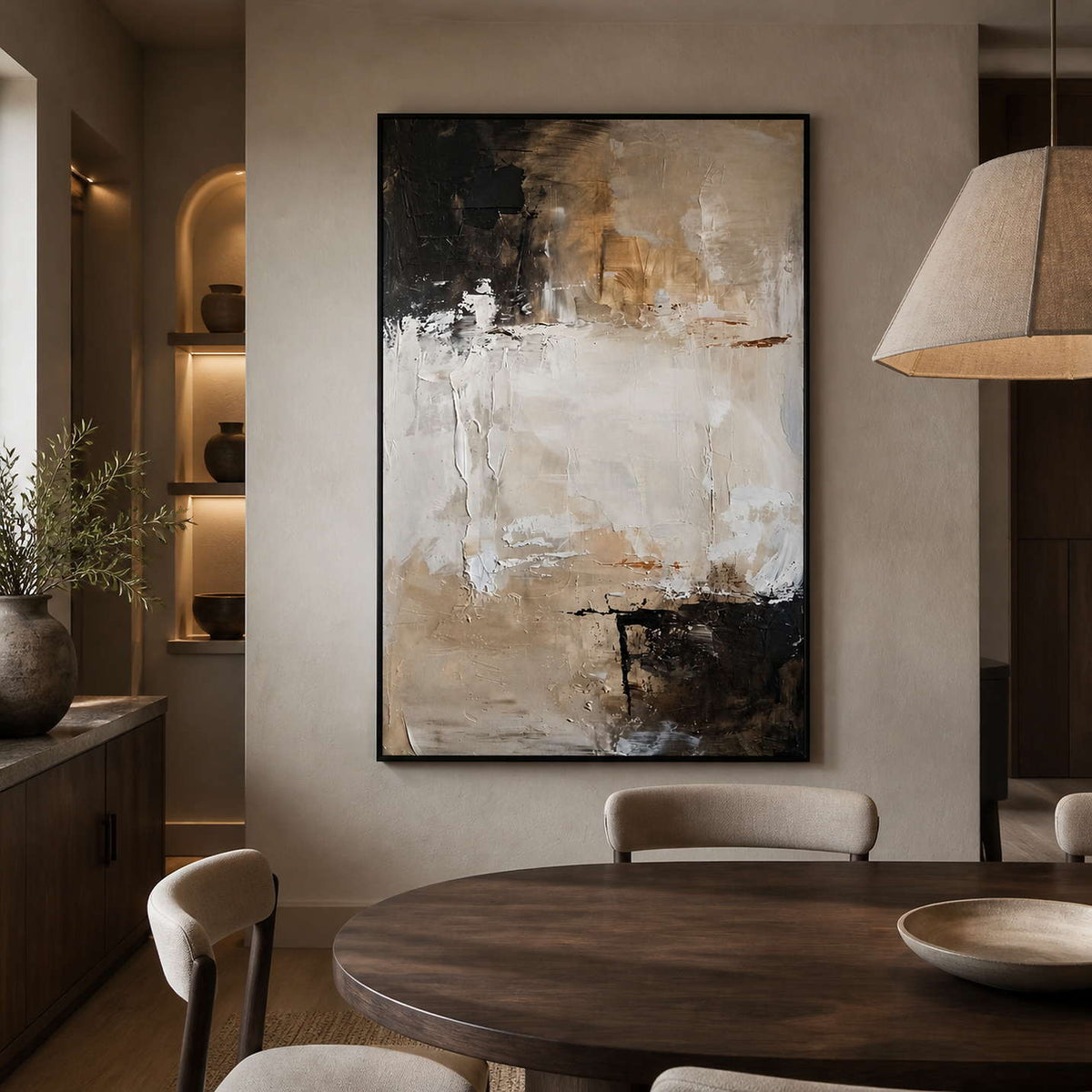 Black framed beige abstract painting displayed beside a dining table.