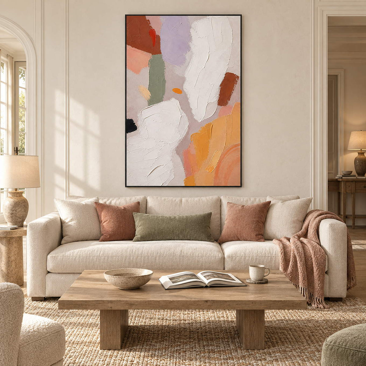 Abstract painting with ivory, lilac, sage, terracotta, and ochre forms in a black frame in a living room.
