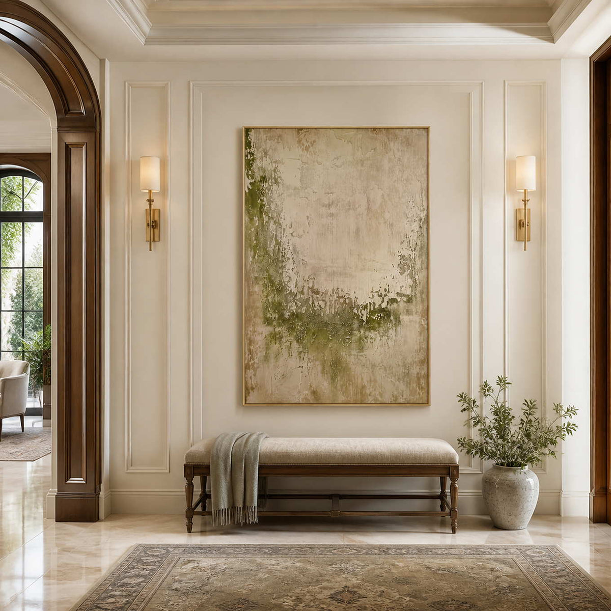 Gold framed pale green abstract painting above an upholstered bench in a bright hallway.